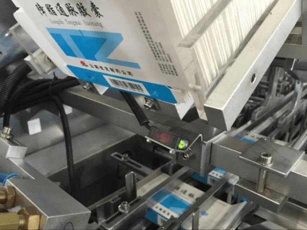 Carton barcode reader and presence sensor verifying carton feed on ZH-200 cartoner