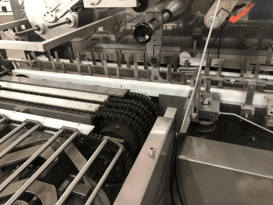 Multi-lane conveyor chain in a high-speed cartoner for synchronized product transport