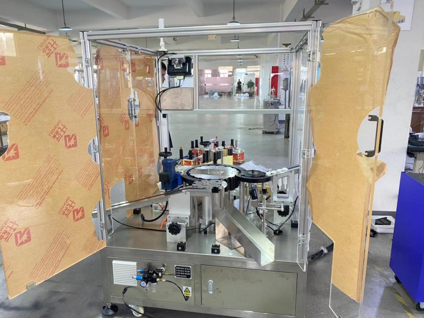 Reference syringe labeling equipment with guarded rotary handling and label feed, shown in the DZA200 technical package